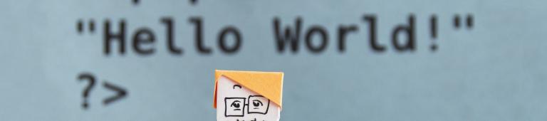Paper figure in front of some PHP code - Image via Unsplash: Kobu agency